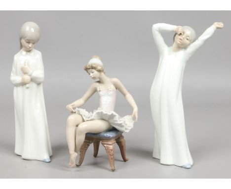 A Lladro figure of a seated ballet dancer, along with two Nao figures of young girls.