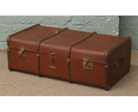 A metal bound travel trunk with upper lift out shelf.