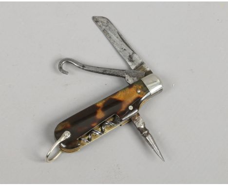 A small multi tool folding pocket knife with tortoise shell scales.