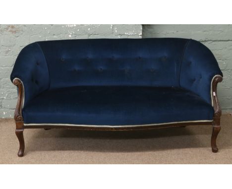 An Edwardian carved mahogany scroll arm sofa upholstered in blue velvet material. Condition Report. To be used as a guide onl