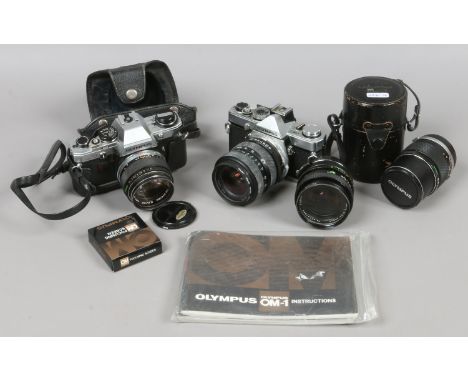 An Olympus 35mm SLR OM1 camera along with Olympus OM10 with manuals and various lenses / cases etc.