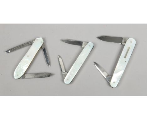 A multi tool folding pocket knife and two other folding pocket knives with mother of pearl scales.