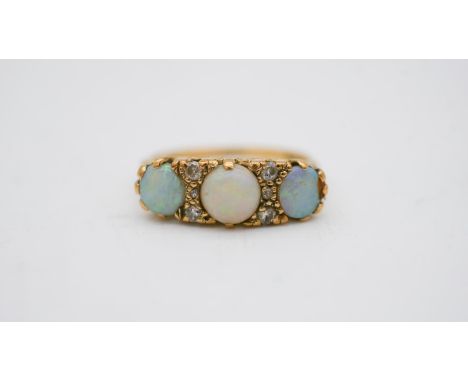 A vintage three stone carved half hoop 18 carat yellow gold opal and diamond ring. Set with three opal cabochons, a total app