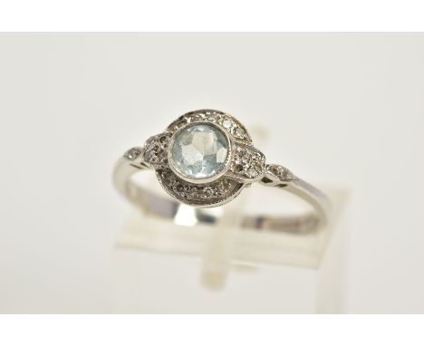 A 9CT WHITE GOLD TOPAZ AND DIAMOND HALO RING, designed with a central, circular cut blue topaz, within a single cut diamond s