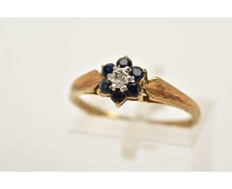 A 9CT GOLD SAPPHIRE AND DIAMOND CLUSTER RING, designed with a central single cut diamond, circular cut sapphire surround, tap