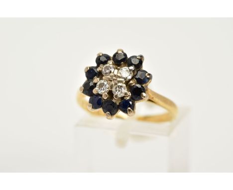 A SAPPHIRE AND DIAMOND CLUSTER RING, the yellow metal cluster ring set with four round brilliant cut diamonds, within a circu