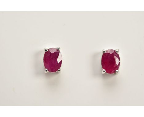 A MODERN PAIR OF 18CT WHITE GOLD RUBY SINGLE STONE STUD EARRINGS, rubies measuring approximately 5.0mm x 3.8mm, hallmarked 18