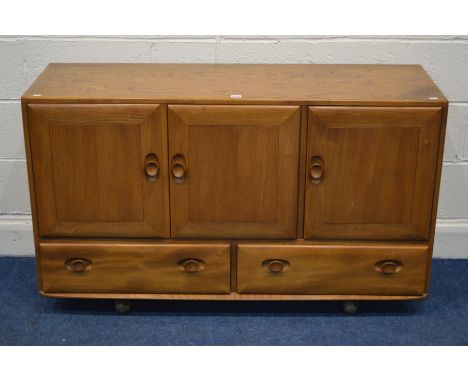 AN ERCOL BLONDE ELM MODEL 468 SIDEBOARD with triple doors revealing two sections and single cutlery drawer above two drawers,