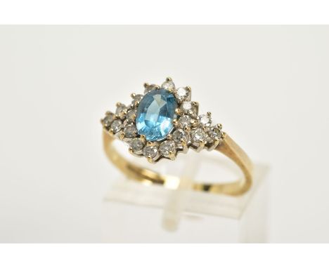 A 9CT GOLD BLUE TOPAZ AND DIAMOND CLUSTER RING, designed with an oval cut blue topaz within a round brilliant cut diamond sur