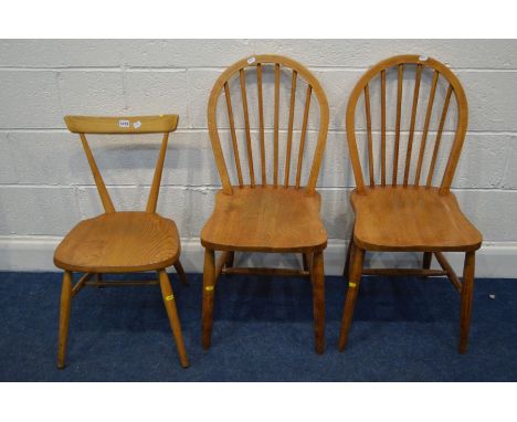 AN ERCOL BLONDE ELM STACKING CHAIR together with a pair of mid 20th Century blonde elm spindle hoop back chairs (3)