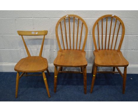 AN ERCOL BLONDE ELM STACKING CHAIR together with a pair of mid 20th Century blonde elm spindle hoop back chairs (3)