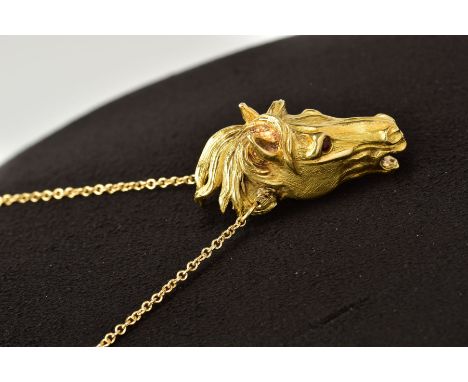 A MODERN HORSE HEAD PENDANT, realistically stylized, textured finish with ruby eyes, pendant measuring approximately 36.0mm x
