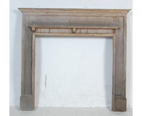 A 19th century Victorian oak fireplace of simple form having a pediment top over a single shelf raised on two large supports.