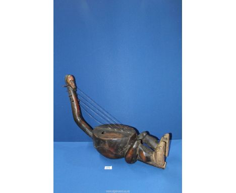 A Tribal Mangbetu four setting anthropomorphic harp with finely carved head,the hide cover stretched over a round wooden body