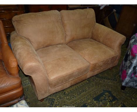 A light brown suede type upholstered two seater Settee, complete with two scatter cushions.