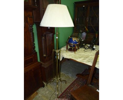 A stylised Brass and other metals Standard Lamp adjustable for height, complete with a beige shade and standing on three unus