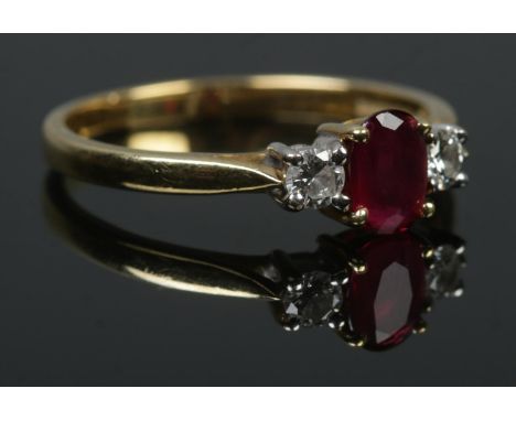 An 18ct gold diamond and ruby three stone ring. Size Q. 3.1g.  