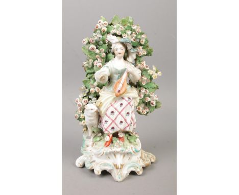 An 18th century Derby porcelain figure modelled as a loot player with bocage surround. 20cm.  Restoration to one of the base,