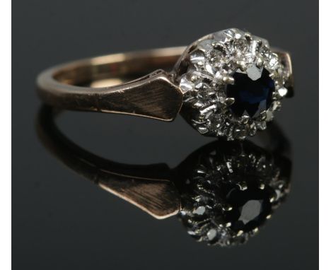 A 9ct gold diamond and sapphire halo cluster ring. Hallmarks for 1981 by B&amp;S. Size K 1/2. 2.39g.  