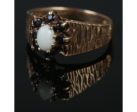A 9ct gold opal and sapphire cluster ring. Size O. 3.83g.  