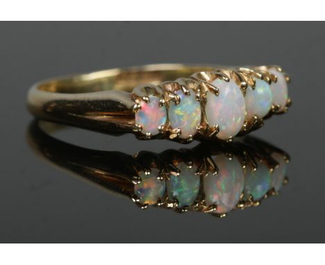 An 18ct gold five stone opal ring. Size Q. 4.29g.  