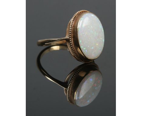 A 9ct gold dress ring set with a large opal stone. Opal stone 1.7cm x 1.2cm. Size Q. 3.32g.  