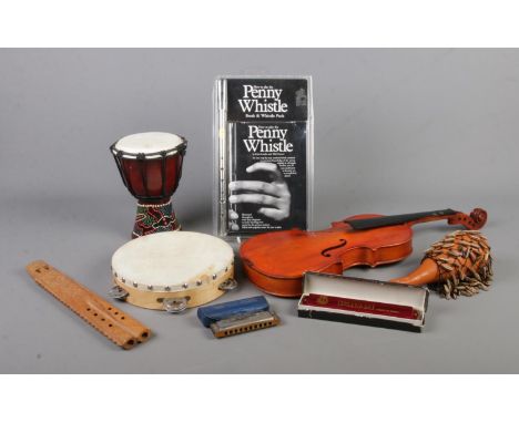 A collection of assorted musical instruments, to include small bongo, tambourine, penny whistle and harmonicas.  Violin missi