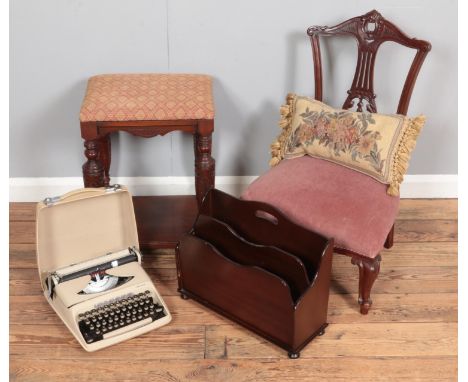 A heavily carved nursing chair together with an upholstered stool, magazine rack and student typewriter.  