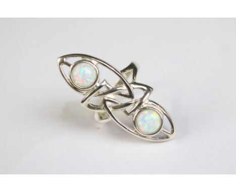 A silver art nouveau style dress ring with two opal panels 