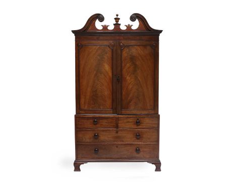 A George III Mahogany and Satinwood-Banded Linen Press, early 19th century, the swan neck pediment centred by an urn finial a