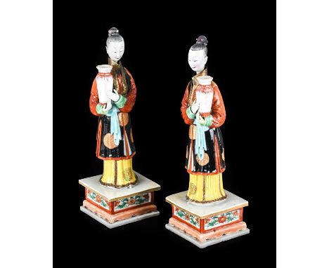 ~ A Pair of Chinese Porcelain "Nodding Head" Figures, Qianlong, each modelled standing holding a square section baluster vase