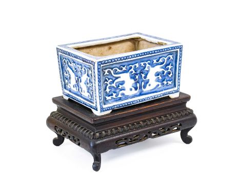 A Chinese Porcelain Planter, Qing Dynasty, probably 18th century, of rectangular form, moulded with taotie on a blue ground w