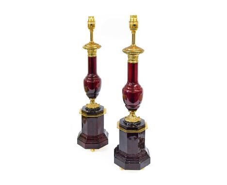 A Pair of French Gilt-Metal-Mounted Ruby Glass Lamp Bases, 20th century, of baluster form with leaf-cast socles, octagonal co