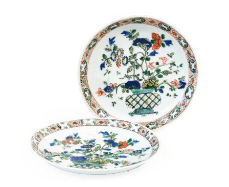 A Pair of Chinese Porcelain Saucers, Kangxi, painted in famille verte enamels with baskets of flowers within a panelled borde
