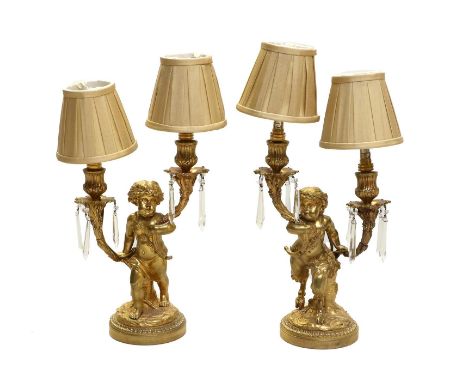 A Pair of French Gilt-Metal Figural Twin-Light Candelabra, in Louis XVI style, with foliate scroll branches supported by Pan 