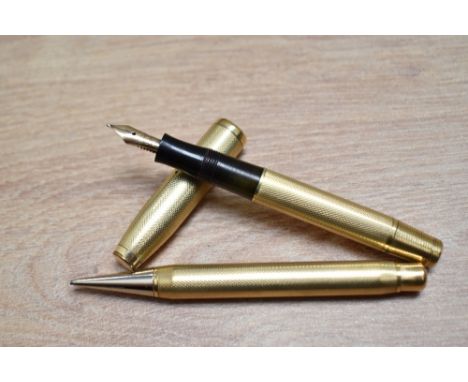 A gold fill, piston fill fountain pen and propelling pencil set in barleycorn pattern having a warranted 585 14K 56 nib. Leat