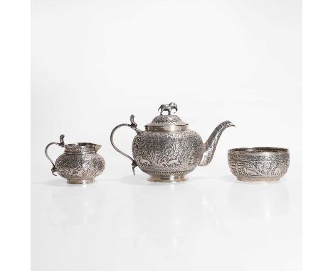 A white-metal three-piece tea set, c.1890, Indian, each piece densely decorated with forest and animal bands, the teapot with