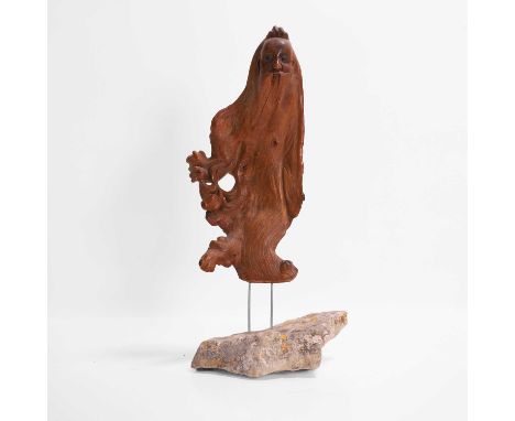A rootwood figure, 20th century, possibly Chinese, on a boulder plinth,13cm wide11cm deep29cm high
