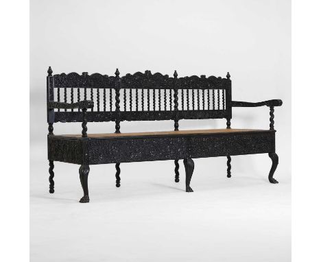 A coromandel and ebony settee, 19th century, Batavian, profusely carved in low relief with panels of urns issuing flowers and