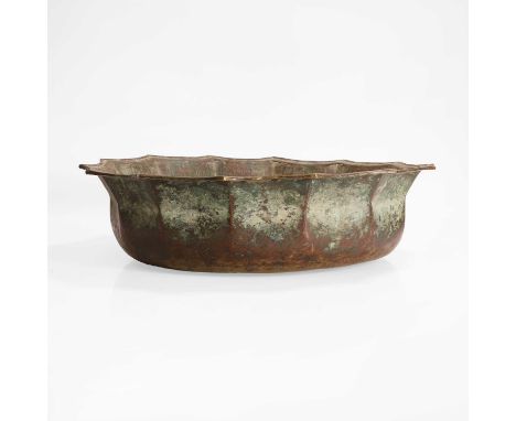 A bronze or brass basin, 12th-14th century, Persian, of faceted round form with bands of Kufic script, with shaped edges, cen
