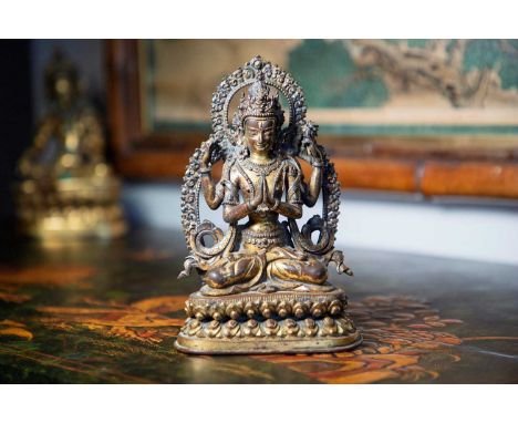 A gilt-copper bodhisattva, 16th century, Nepalese, wearing an elaborate headdress with beaded jewellery and an ankle-length d