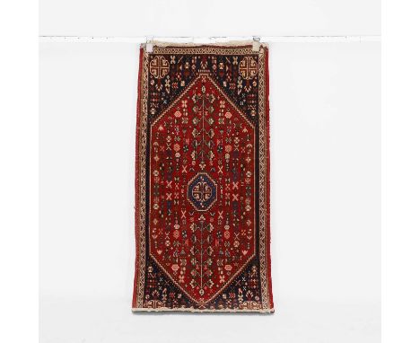 A wool rug, of recent manufacture, the central field with a red-ground hexagonal field within a navy blue border,146 x 67cm 