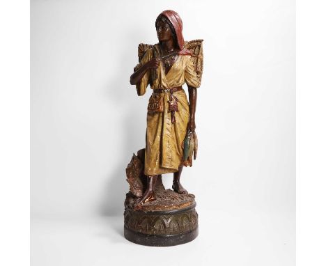 A terracotta figure of a fish seller, late 19th/early 20th century, in the manner of Goldscheider, raised on a circular base 