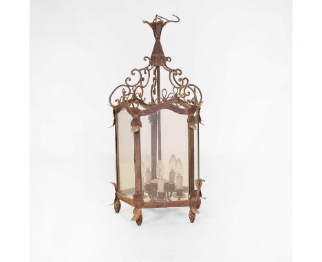 A hexagonal wrought-iron hanging lantern, 20th century, having scrolling supports, applied metal leaf decoration and traces o
