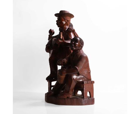 A carved mahogany figural group, 20th century, Cuban, depicting a trio of musicians, the conga drum carved with the inscripti