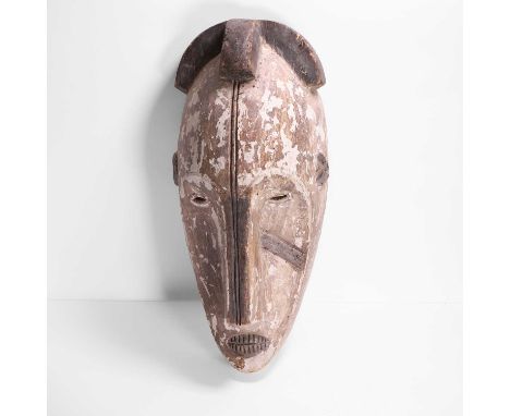 A painted Ngil-type mask, Gabon, Fang people, with elongated nose, leading to raised, arched brows, with narrow cutout eyes b