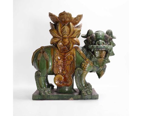 A sancai-glazed figure, possibly Ming dynasty, Chinese, of a Buddhist lion standing on a rectangular plinth, modelled with bu