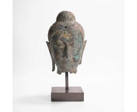 A bronze head of Buddha, 17th century/18th century, Thai, cast with a serene expression, the face framed by pointed ears and 