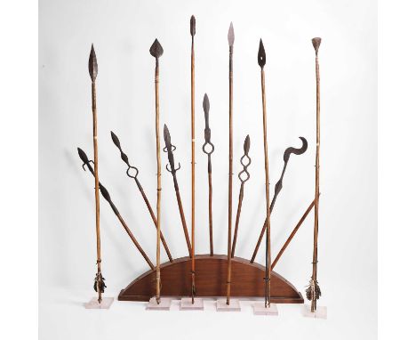 A collection of iron-tipped arrows, 20th century, some with feather fletches,longest 90cm long,together with a hardwood stand