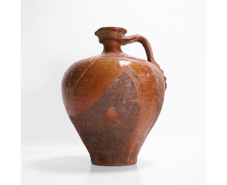 A terracotta oil jar, 19th century, with slip glaze decoration and pulled handle, 20cm diameter28cm high